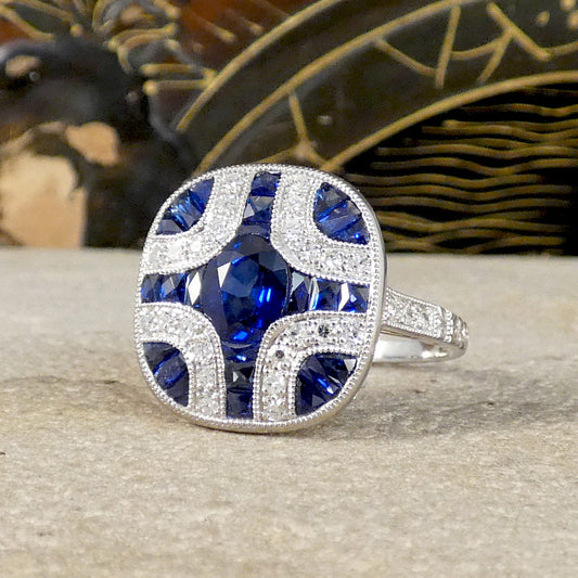 A gorgeous Art Deco style Sapphire and Diamond geometric cross style ring in Platinum. Showing a gorgeous blue hue and quality craftsmanship.