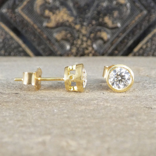 Gold stud earrings with Diamonds on a textured surface