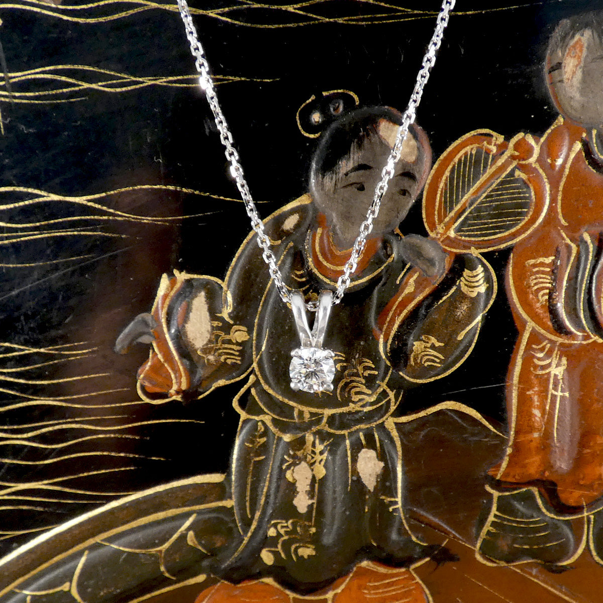 Diamond necklace displayed in front of an ornate, traditional-style painting