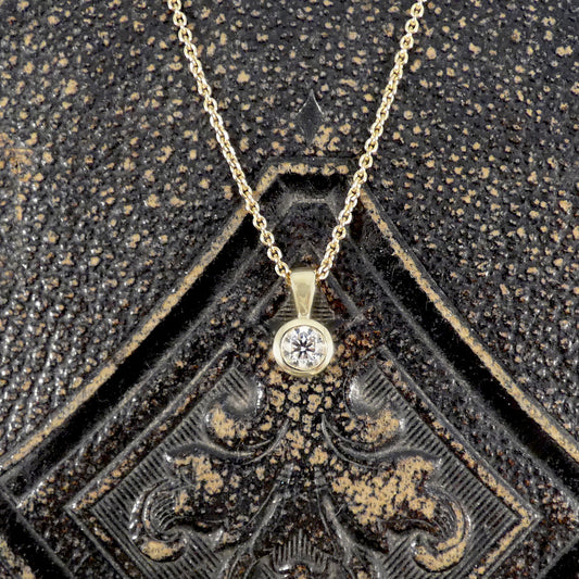 Gold necklace with a diamond pendant on an ornate black and gold background