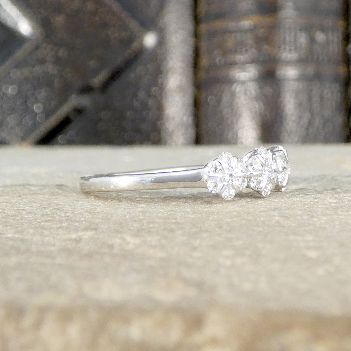 Side profile of diamond five stone cluster  ring with a plain polished band
