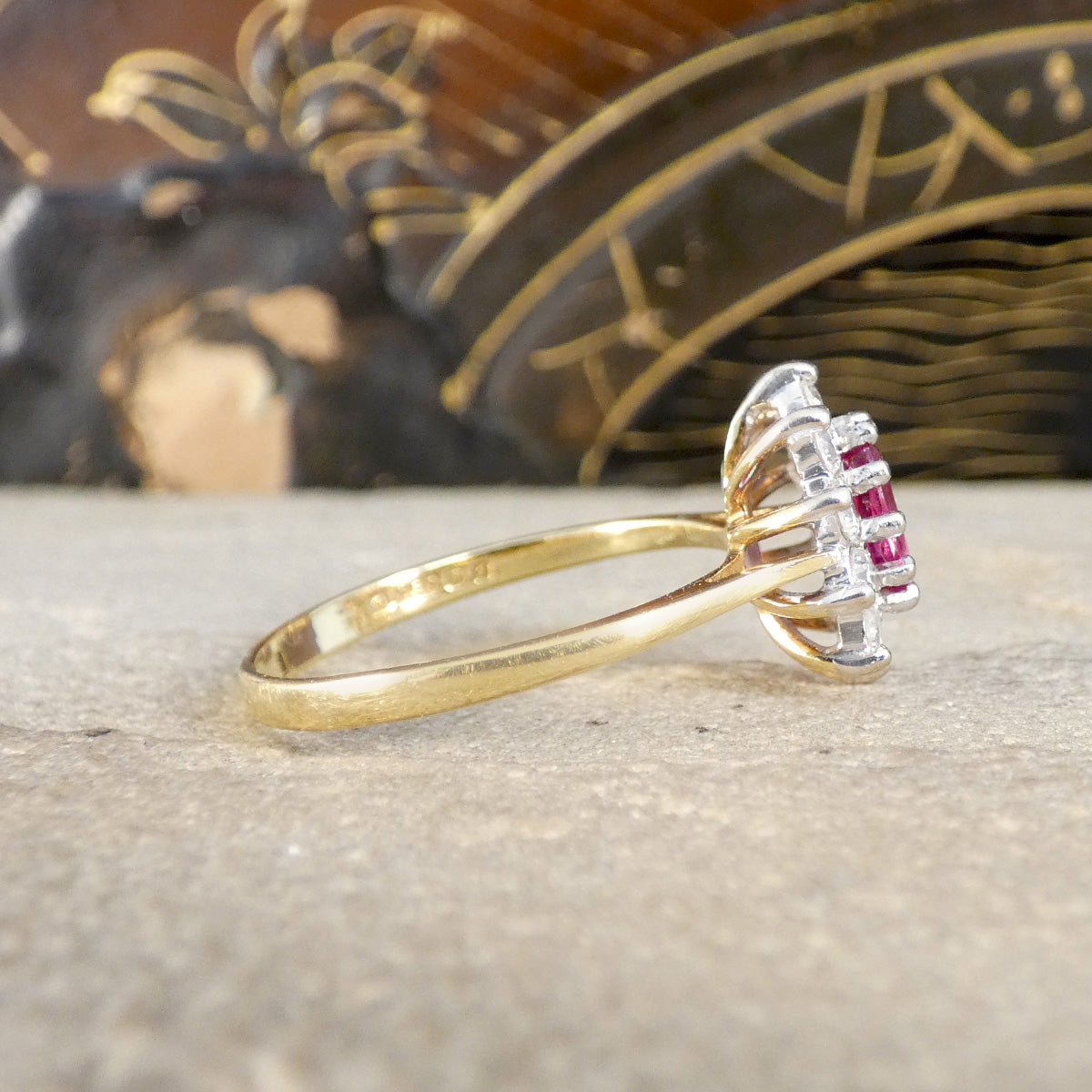 Gold ring with gemstones on a textured surface