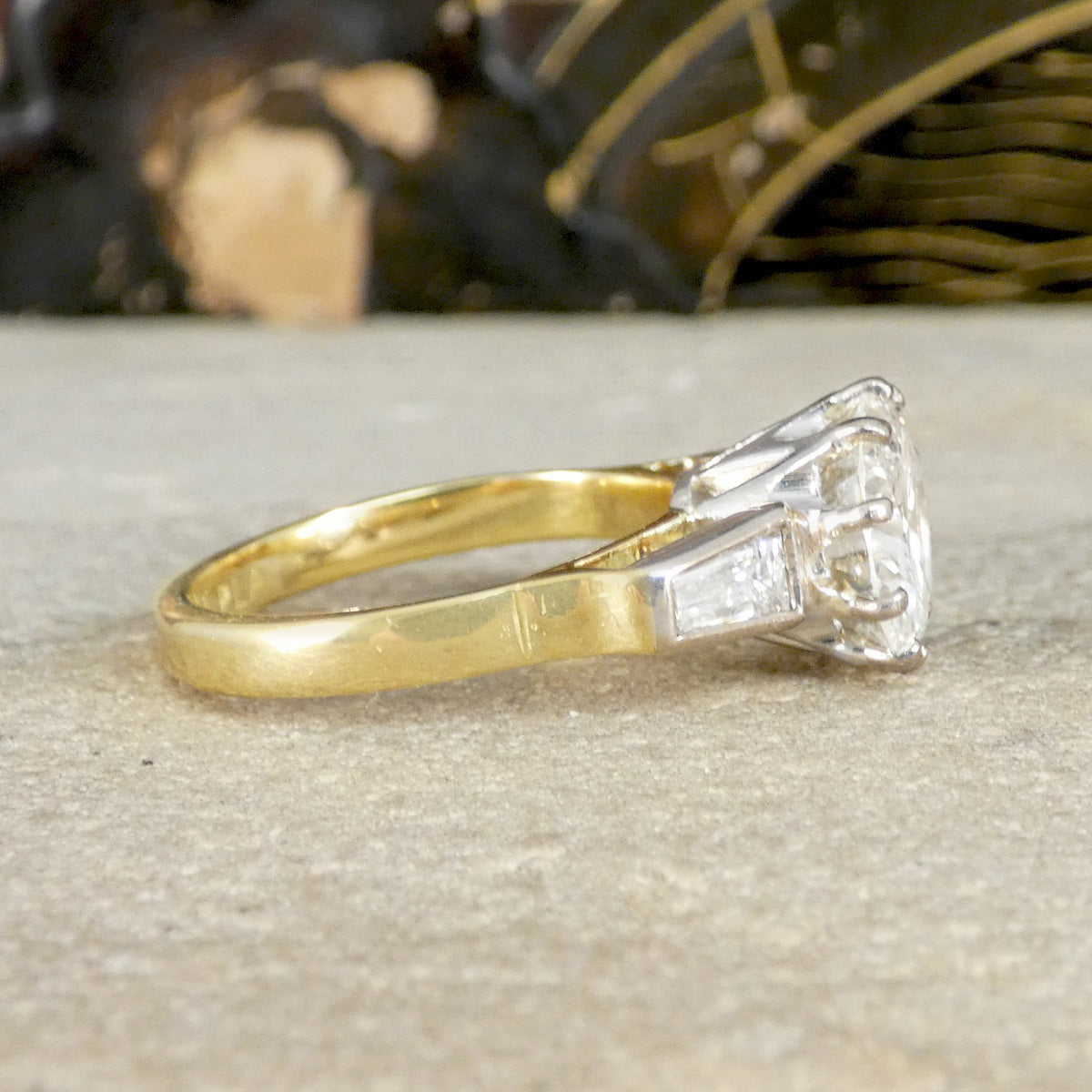 Gold ring with a diamond on a textured surface