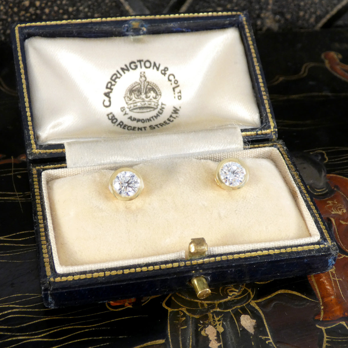 A pair of diamond stud earrings in an 18ct yellow gold rub over bezel setting in a vintage box.