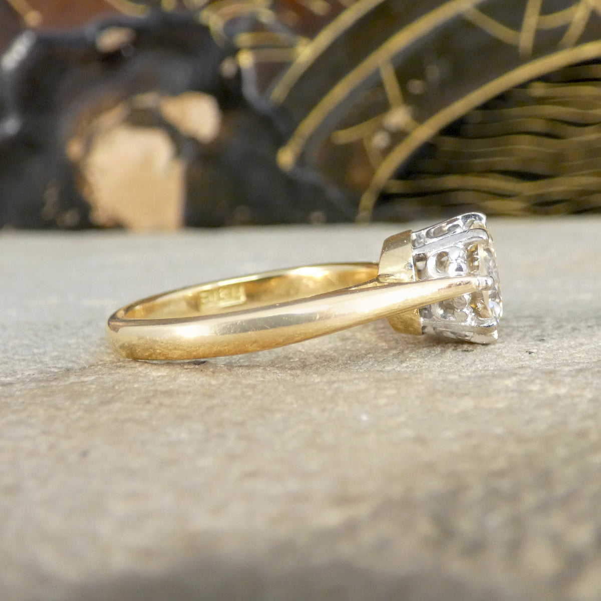Gold ring with a diamond on a textured surface