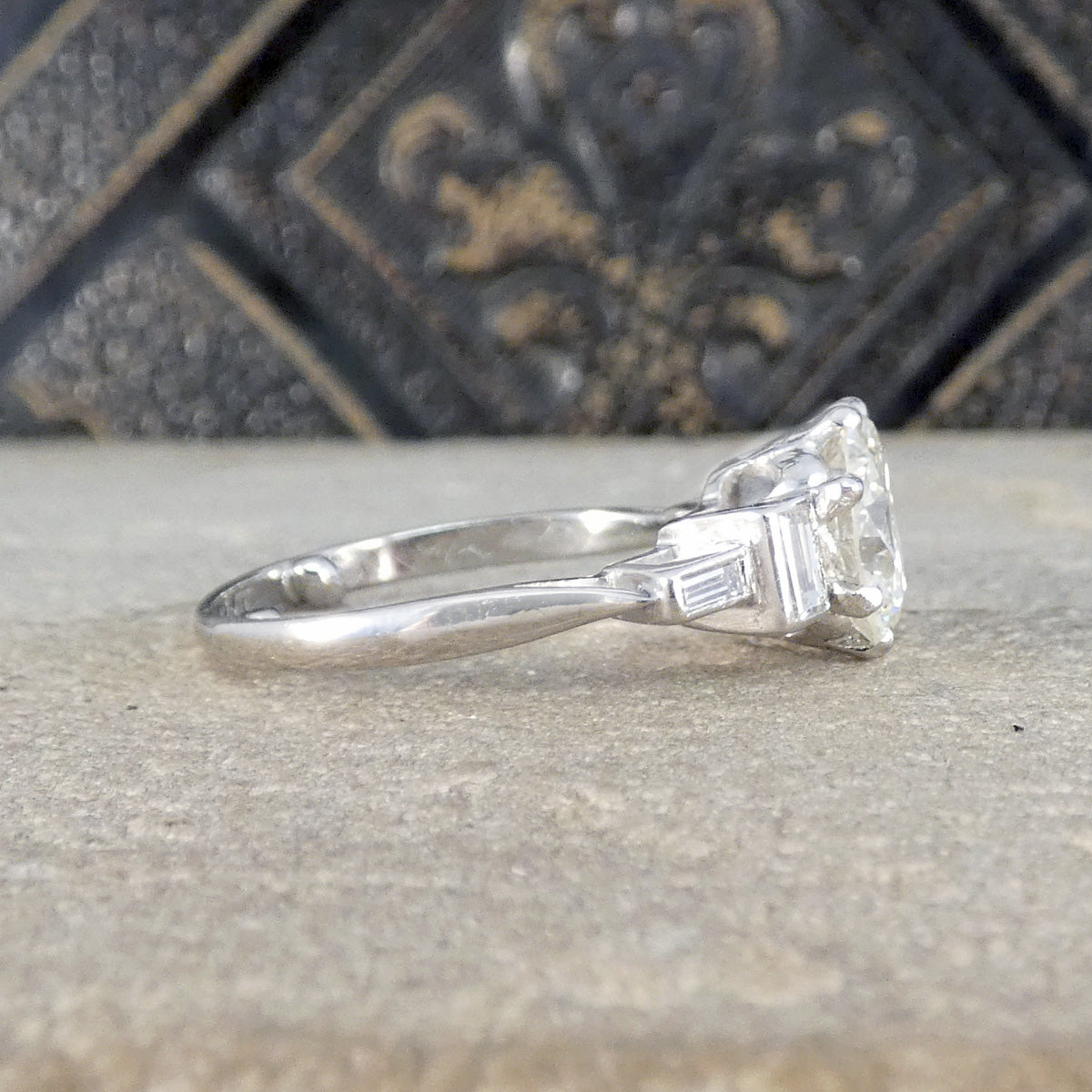 Diamond ring on a textured surface with an ornate background