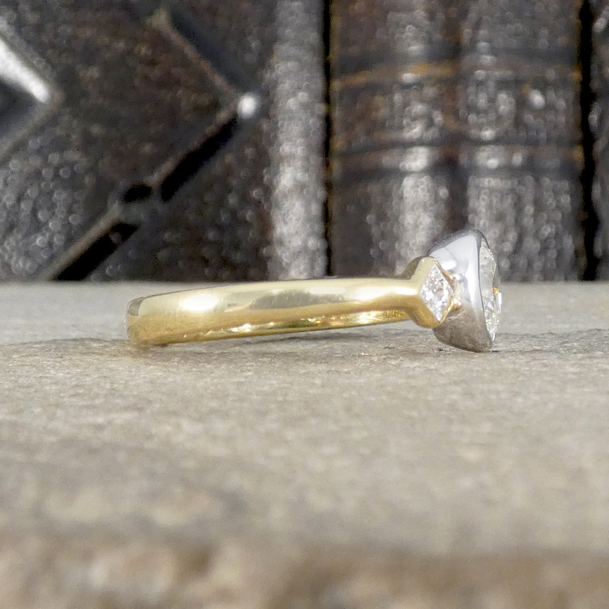 Side view of plain polished band on diamond three stone ring.