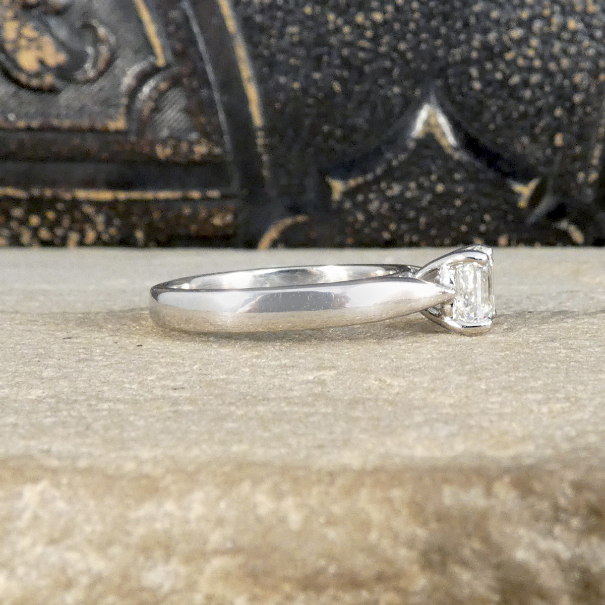 A Squared Emerald Cut Diamond Solitaire Engagement Ring in a four claw setting with a chunky Platinum band and modern feel. GIA cert with wedfit setting.