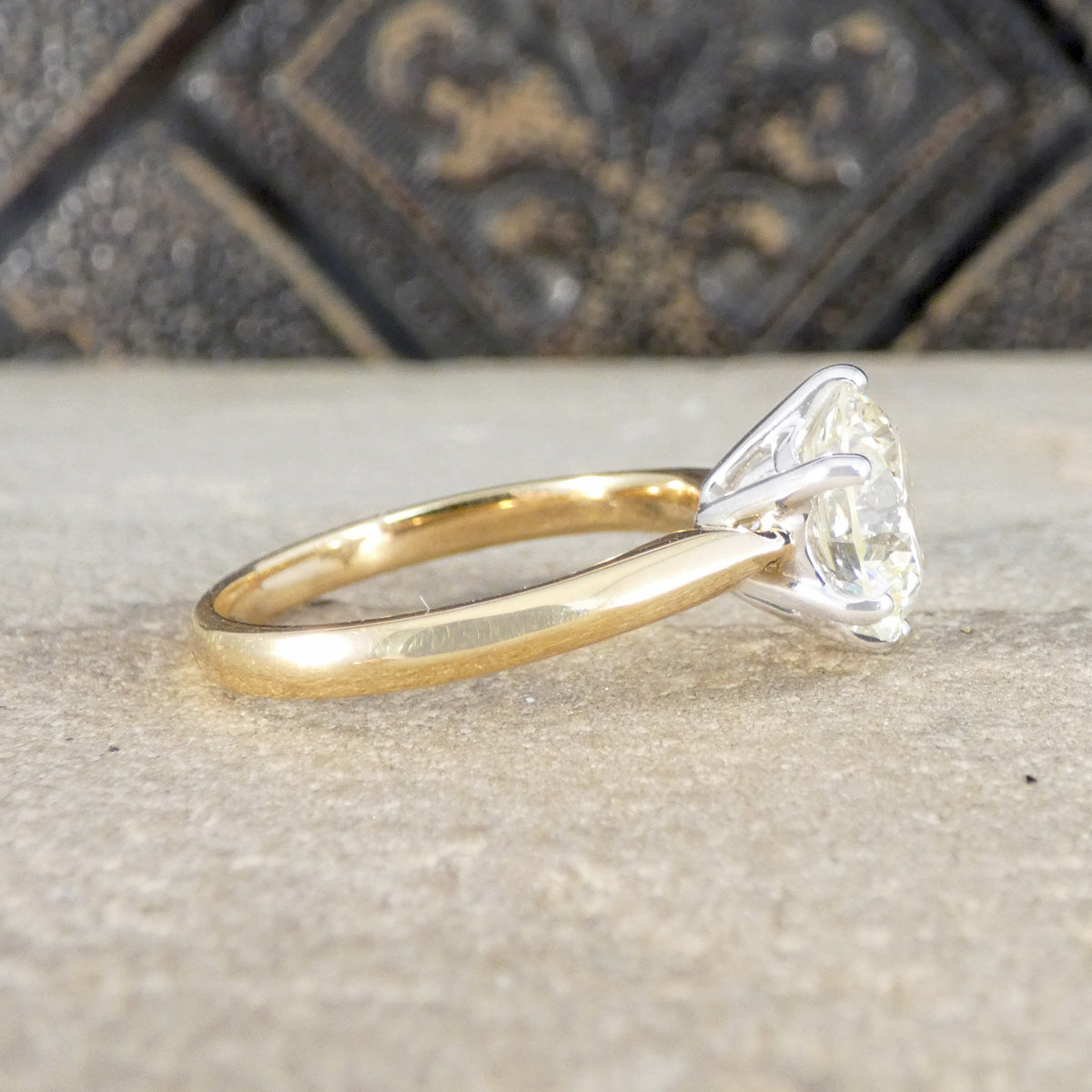 Gold ring with a diamond on a textured surface