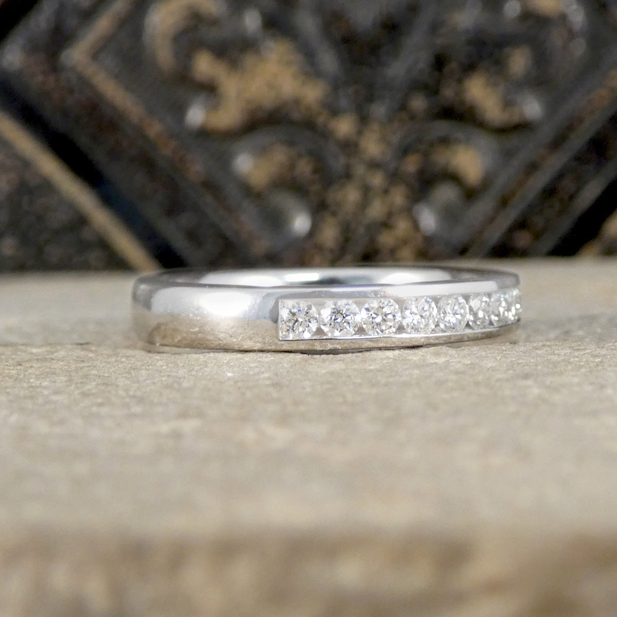 Silver ring with small diamonds on a textured surface