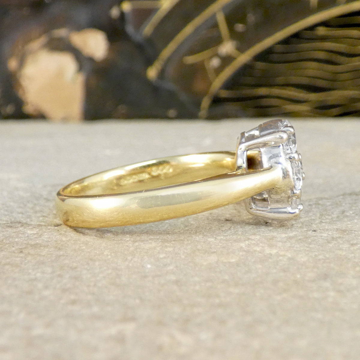 Gold ring with a diamond on a textured surface