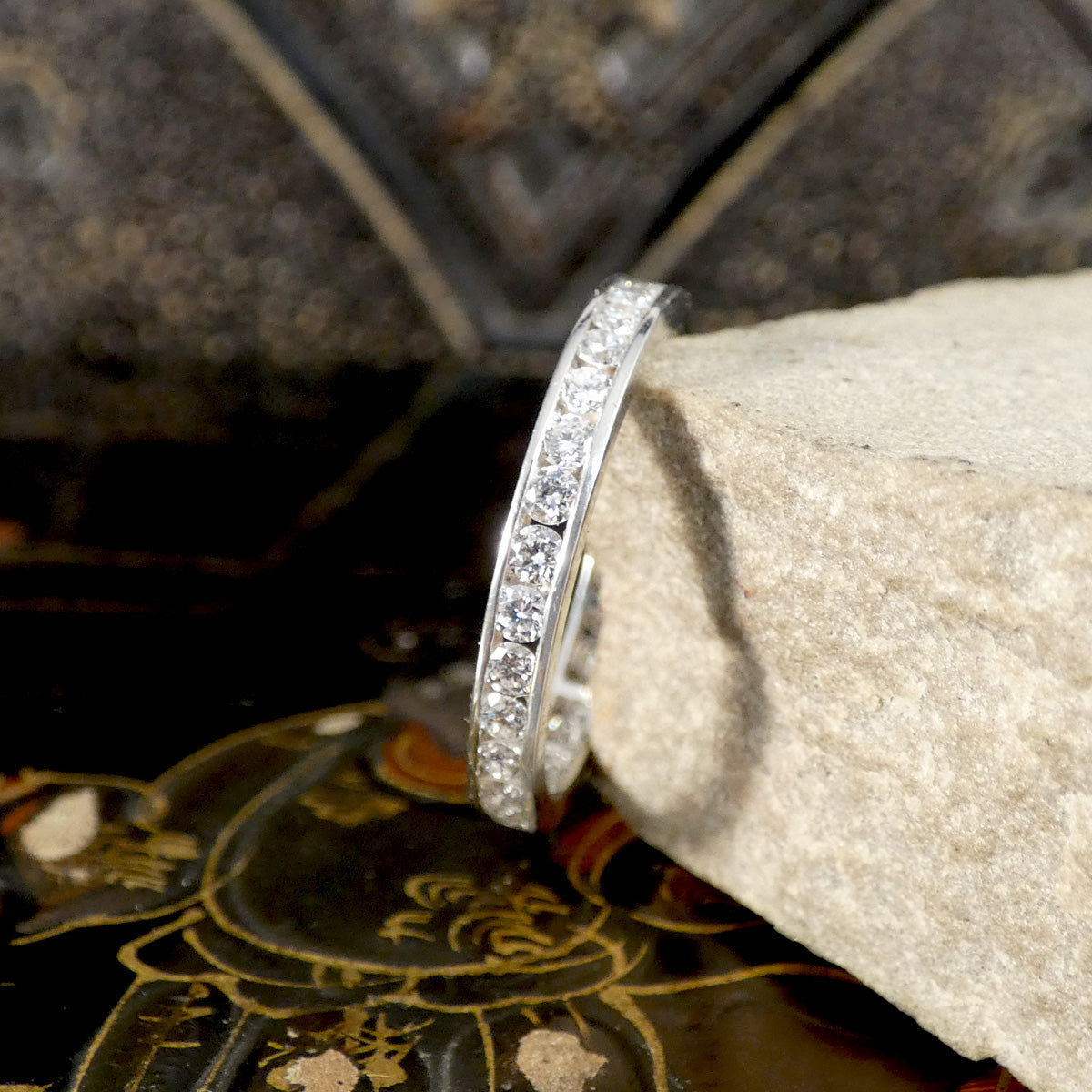 Silver ring with diamonds on a stone surface