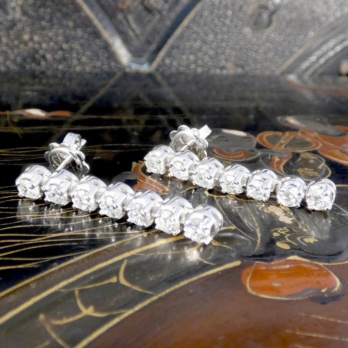 A close up of diamond drop earrings in 18ct white gold.