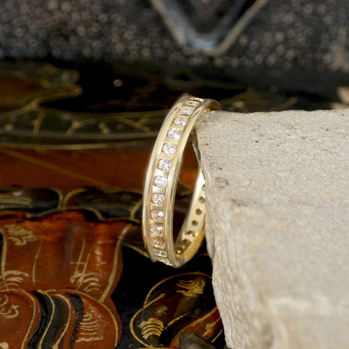 Gold ring with diamonds on a stone surface