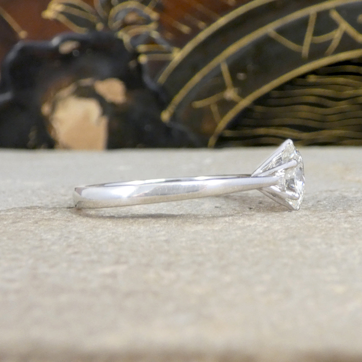 Side view of diamond engagement ring showing open setting allowing light to pass through the diamond and sparkle brilliantly.