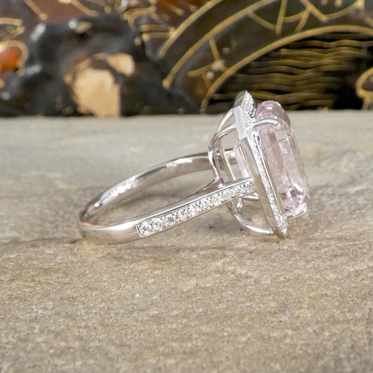 Silver ring with a pink gemstone on a stone surface