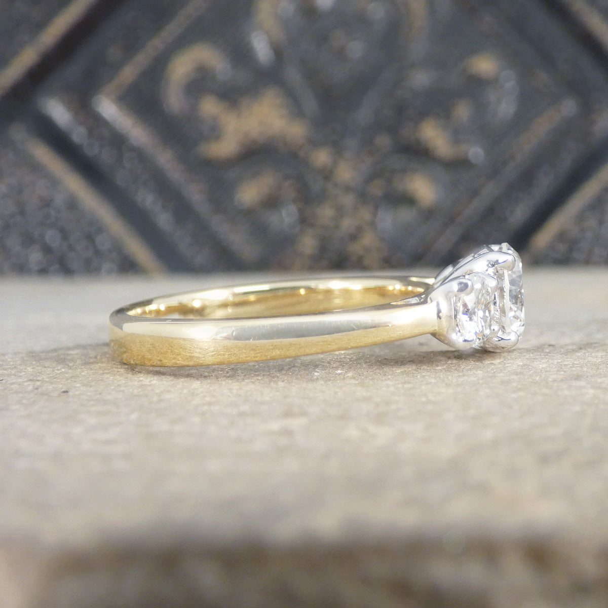 Gold ring with a diamond on a textured surface