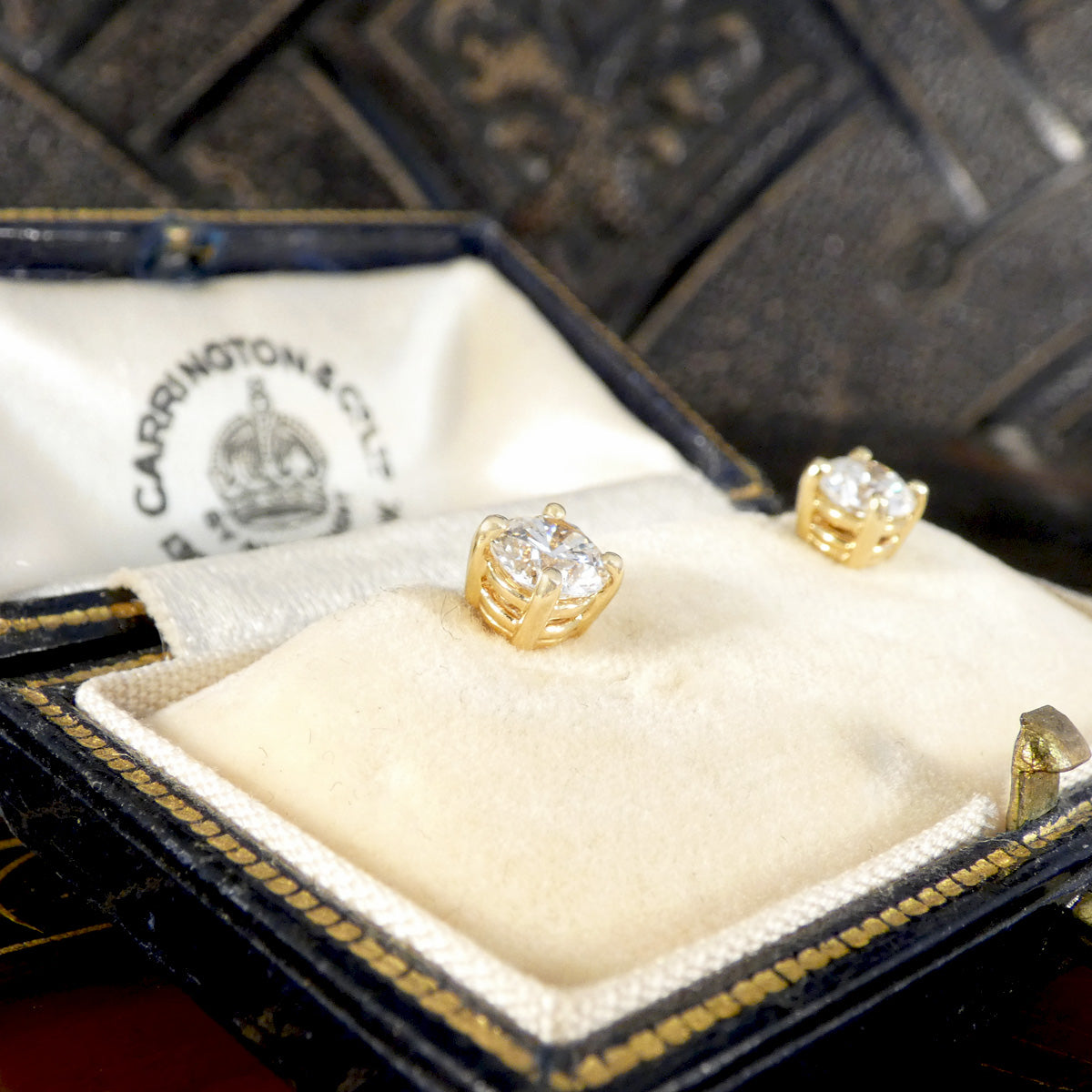 Diamond stud earrings in a classic four claw setting shown from the side profile.