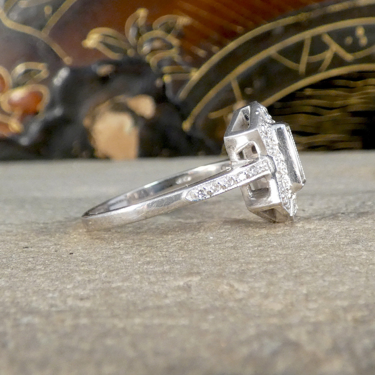 Side view of silver coloured ring with diamond shoulders