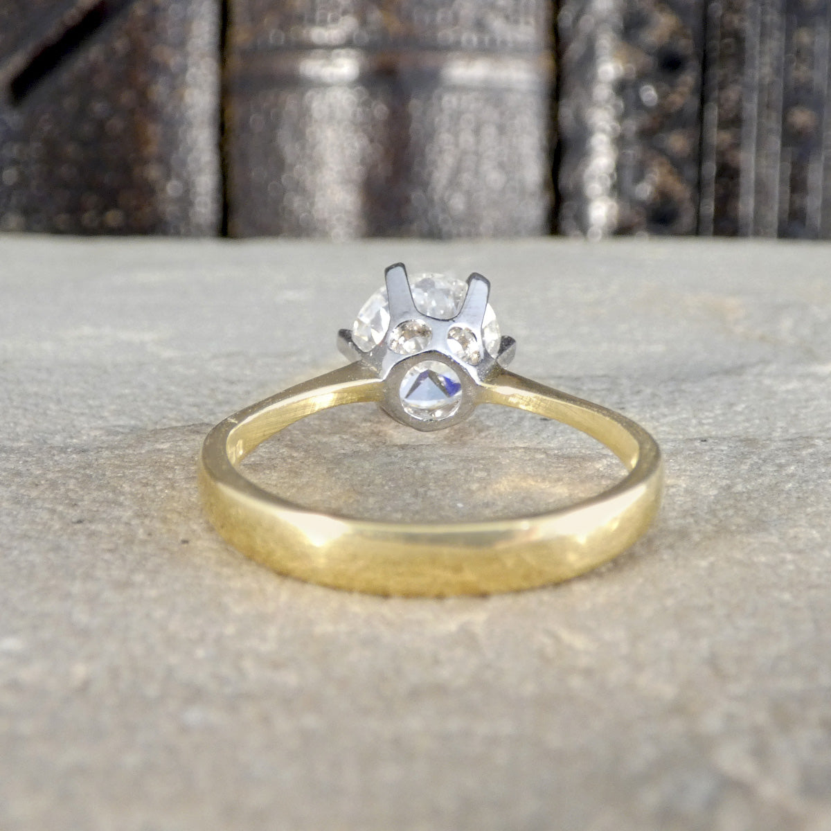 Back view of diamond solitaire ring in gold showing the white gold setting and open to how much light can pass through the stone.