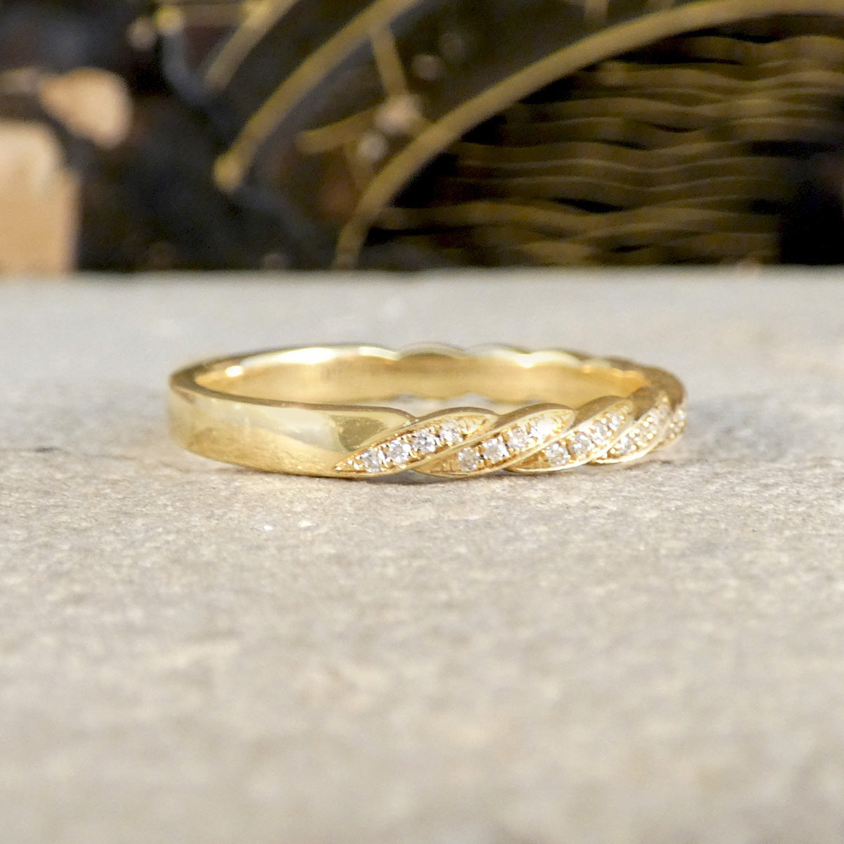 Gold ring with diamond accents on a textured surface