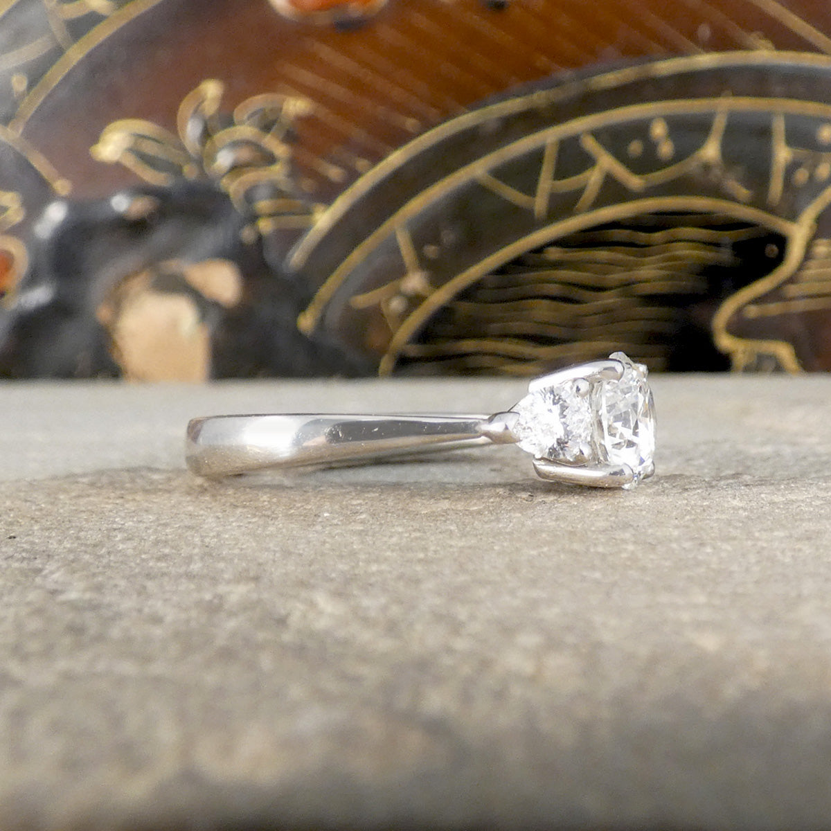 Diamond ring on a textured surface with an ornate object in the background