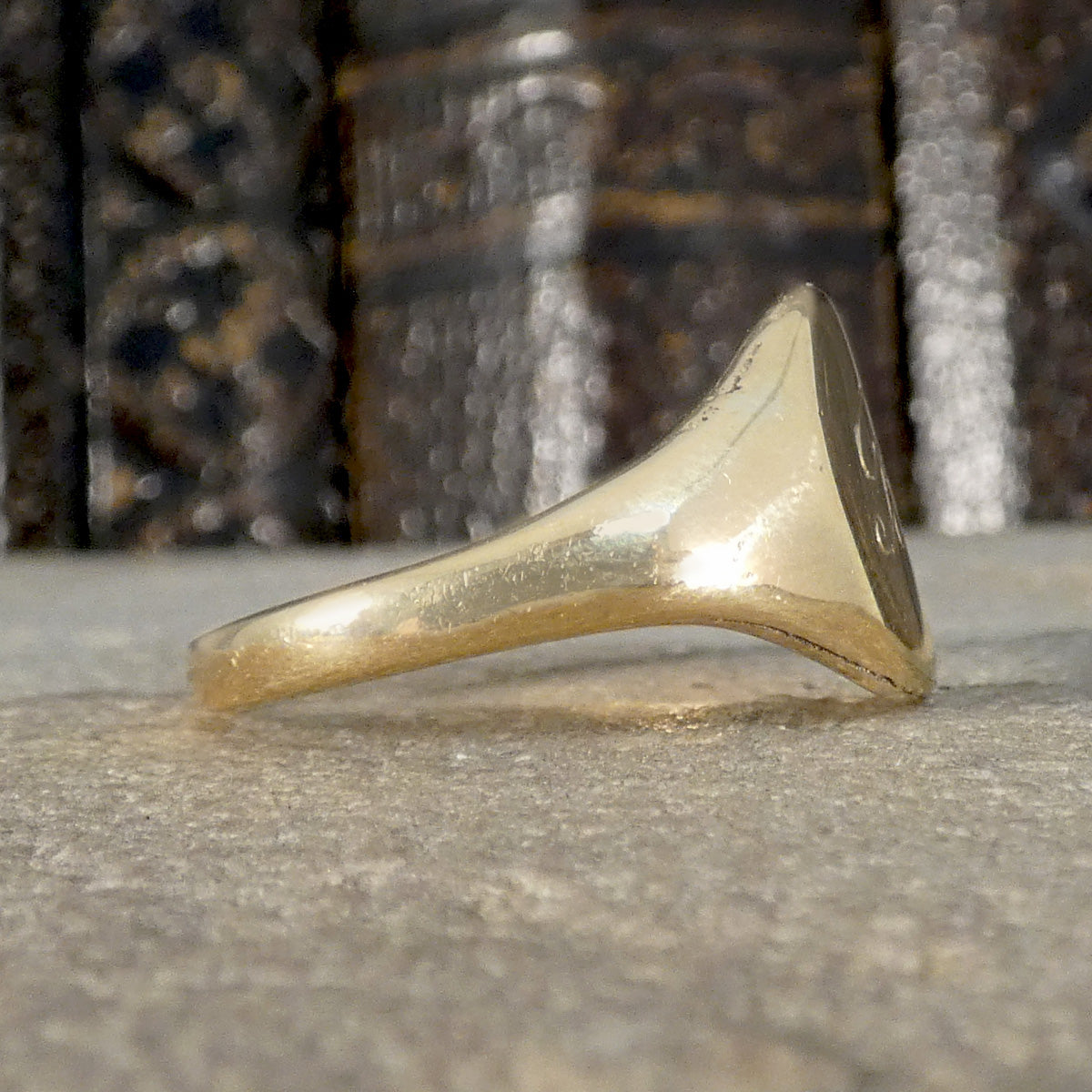 Gold ring on a textured surface with a blurred background