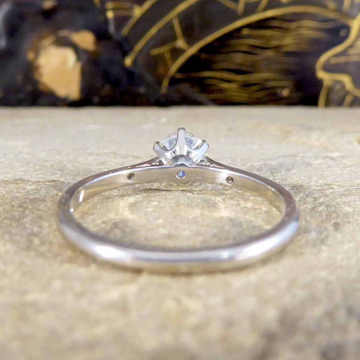 Platinum ring with a diamond on a textured surface