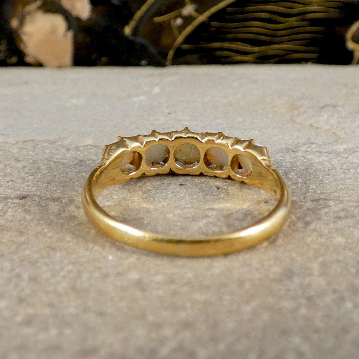 Gold ring with a textured band on a stone surface