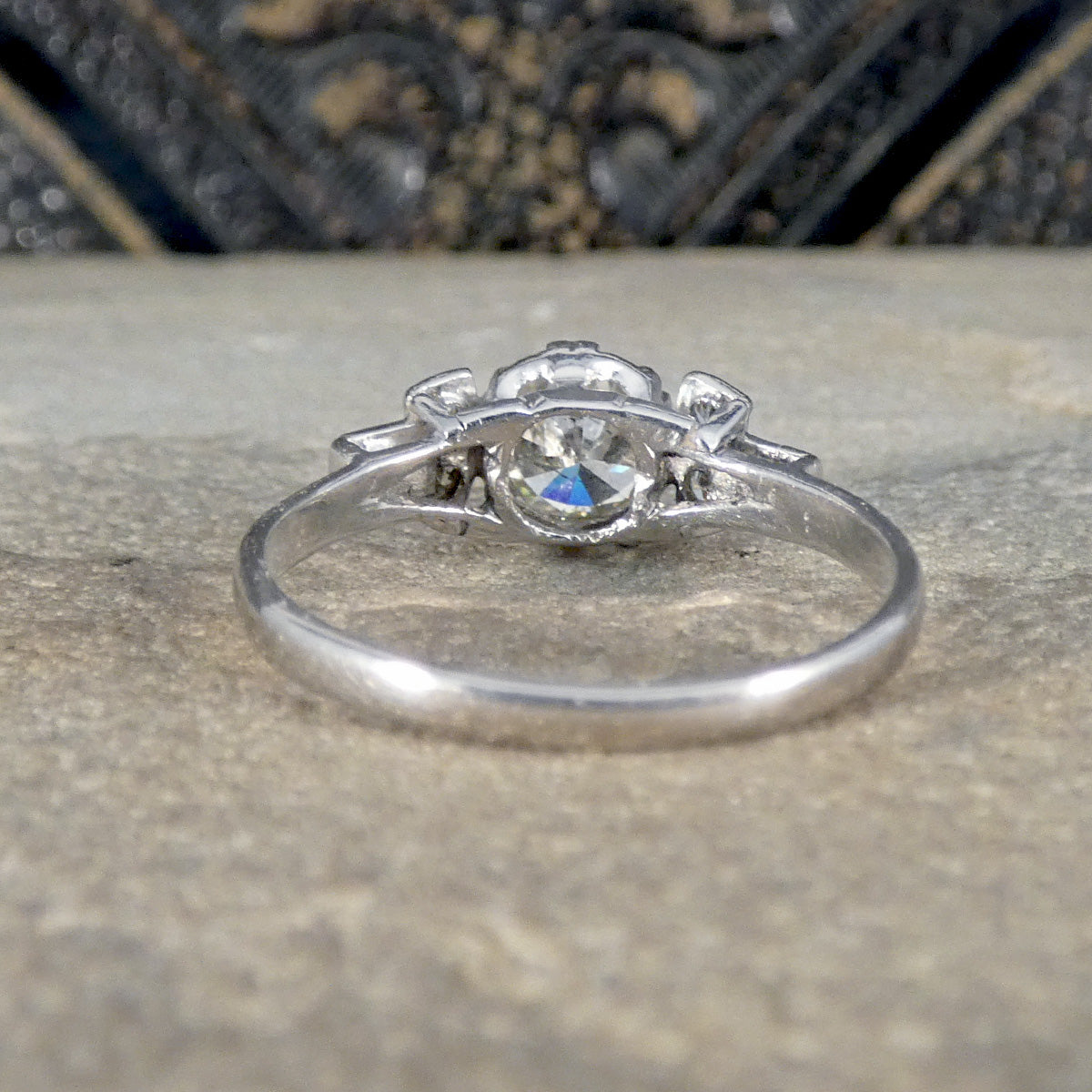 Silver ring with a central gemstone on a textured surface