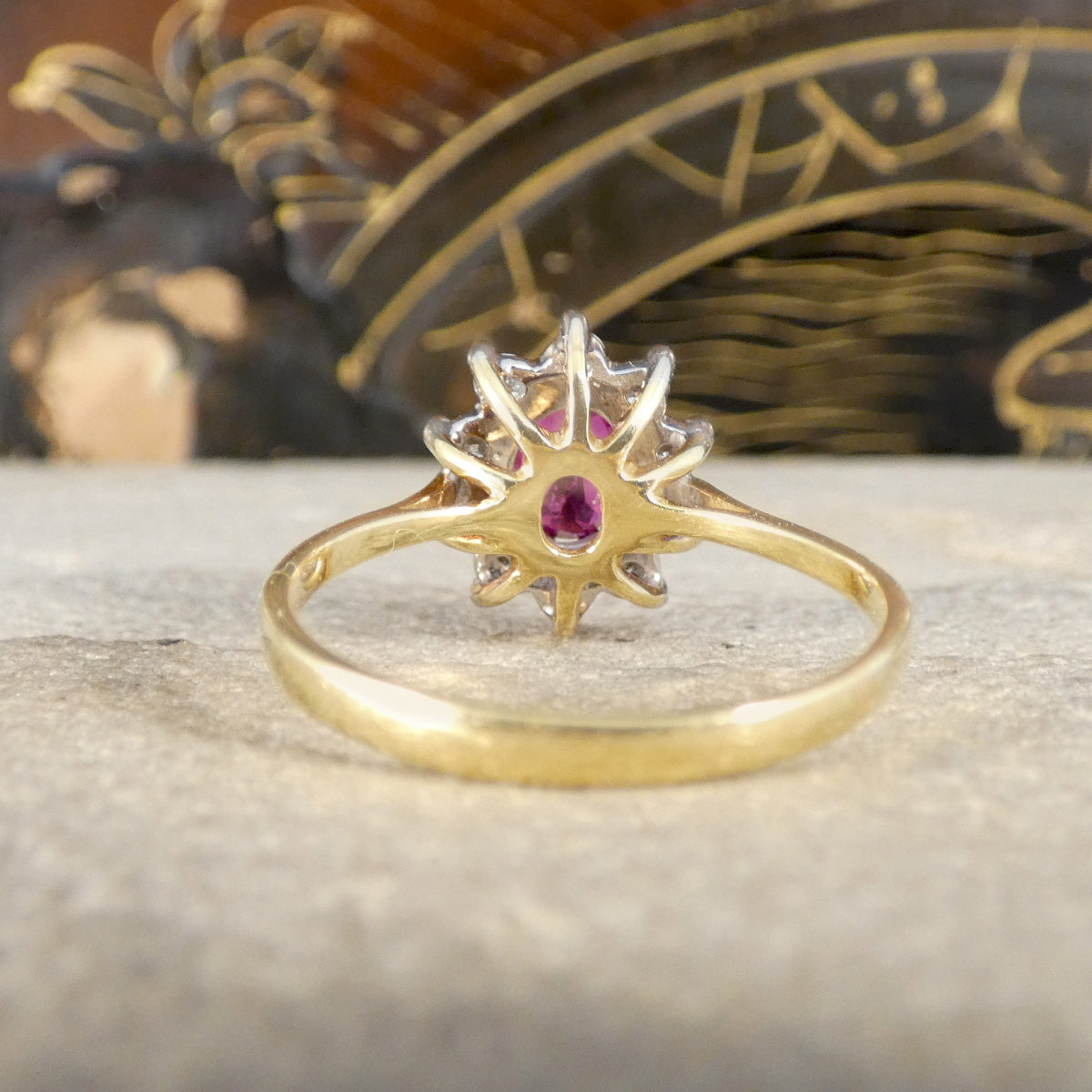 Back view of diamond and ruby cluster ring in gold.