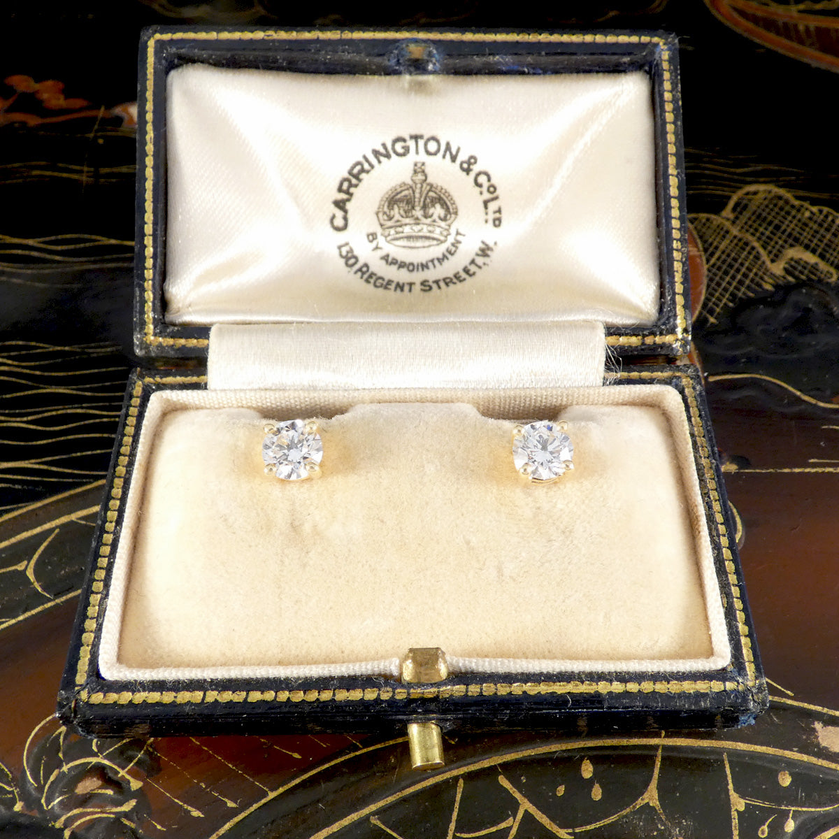 Diamond earrings in a Carrington & Co box on a decorative background
