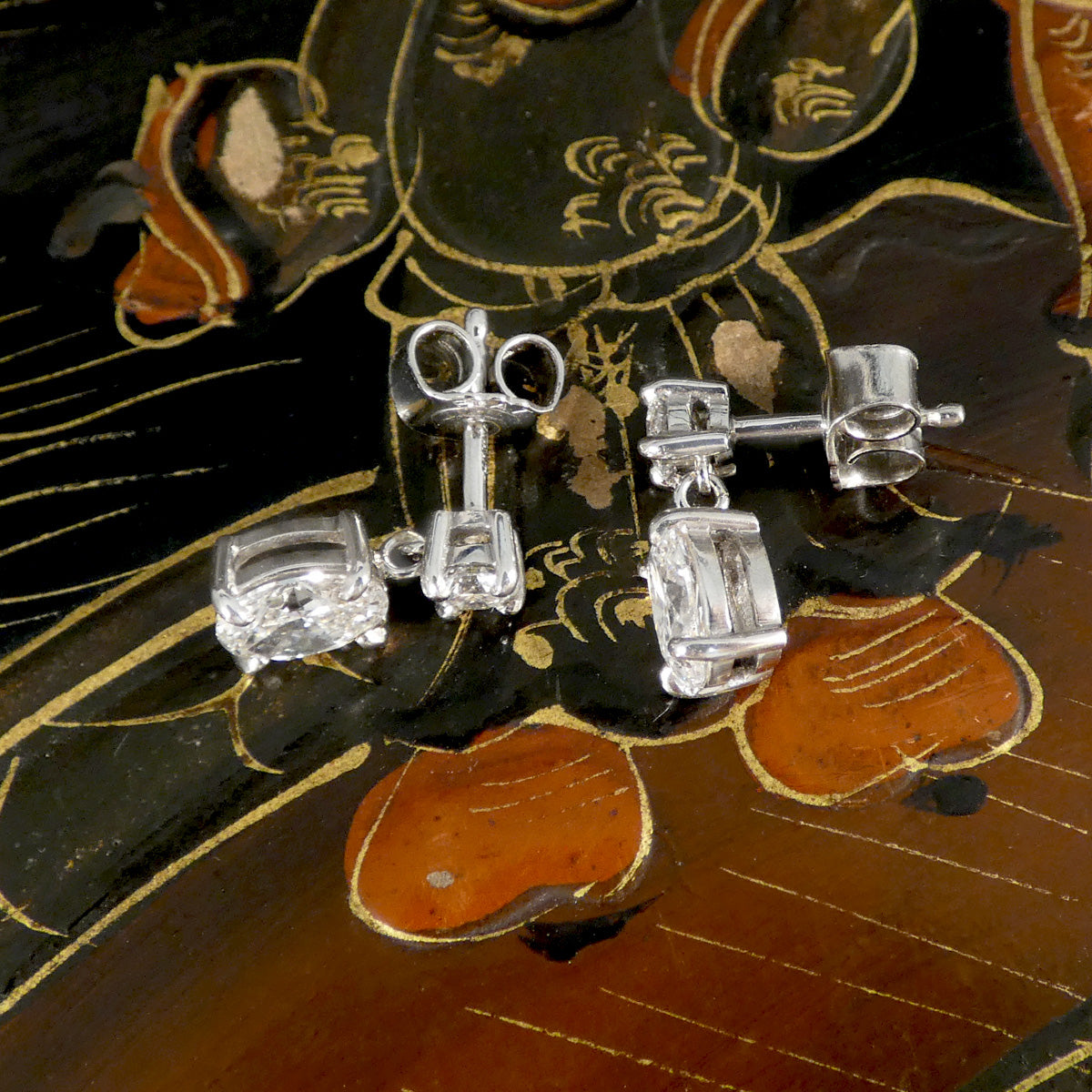 Diamond earrings on a decorative wooden surface