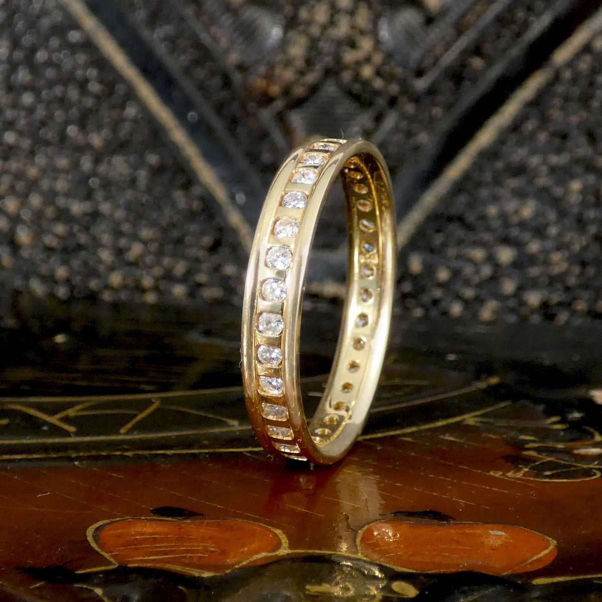 Gold ring with diamonds on a textured surface