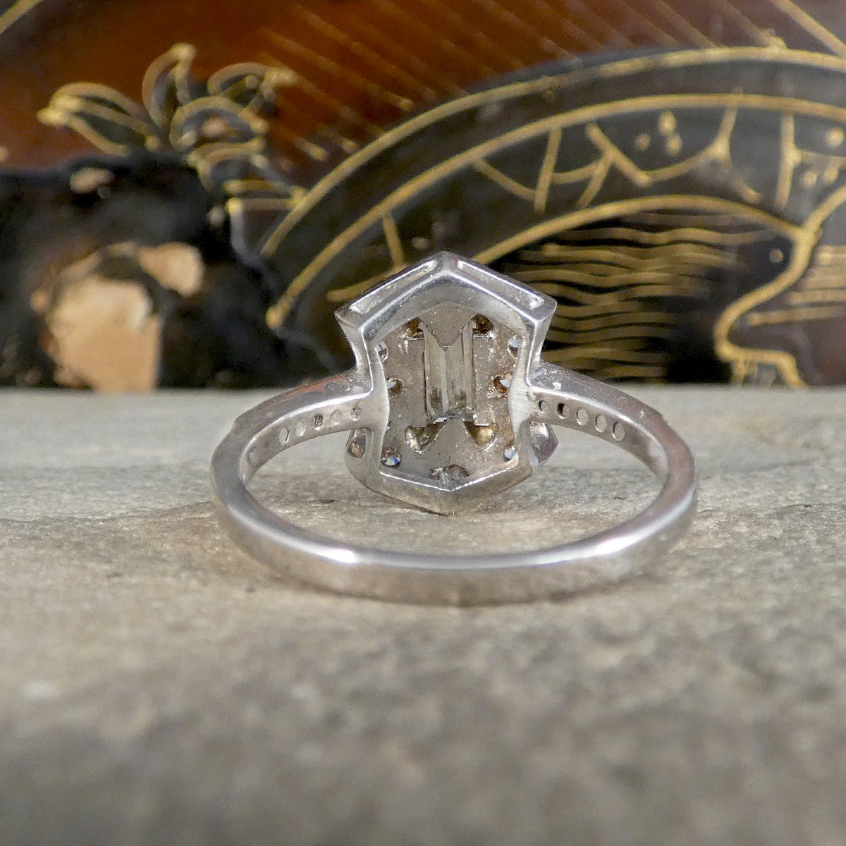 Silver ring with a detailed design on a textured surface