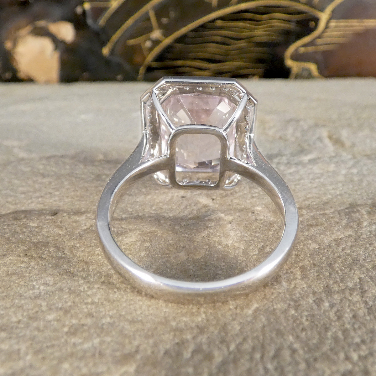 Silver ring with a large square-cut gemstone on a stone surface