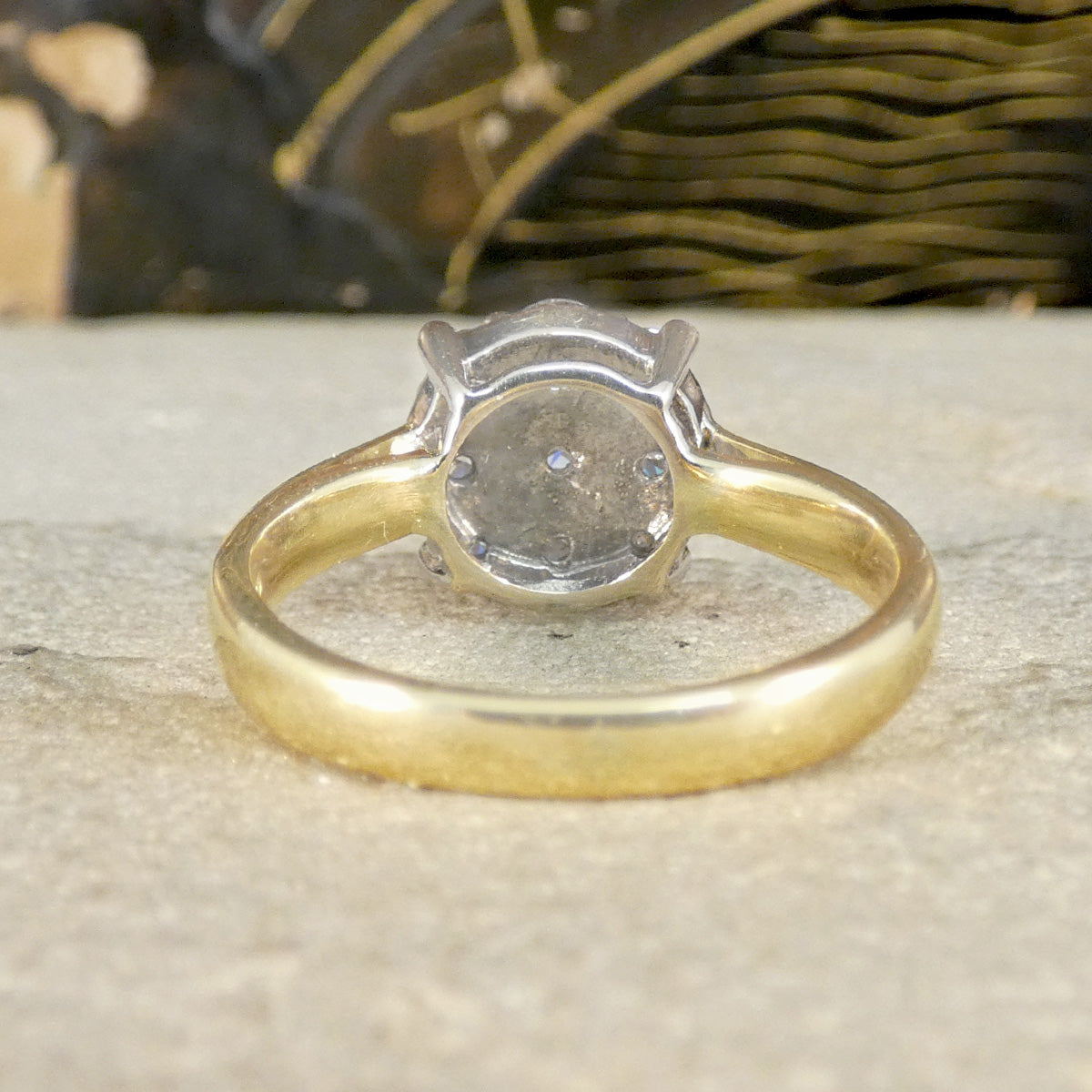 Gold ring with a diamond on a textured surface