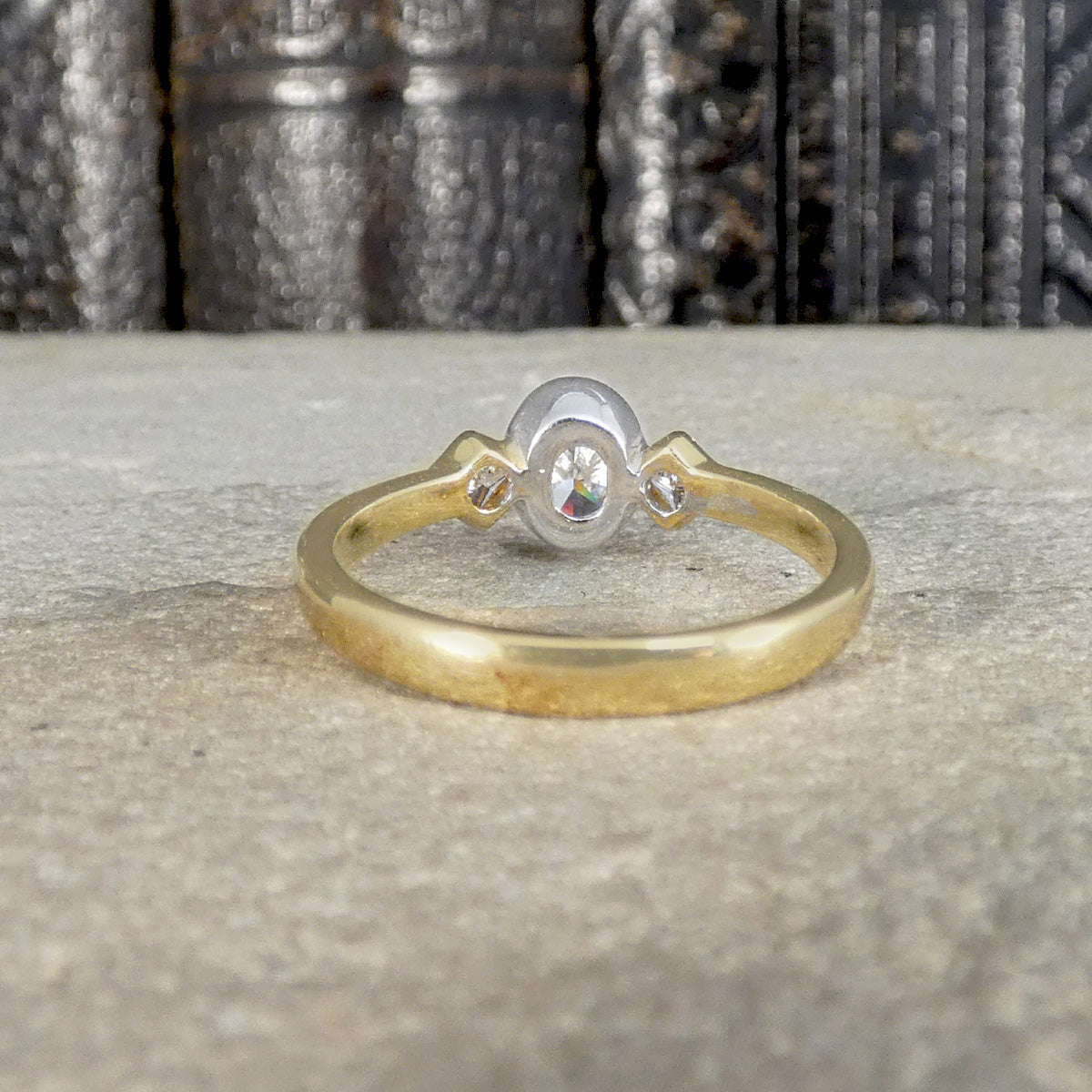 Back view of Oval cut diamond three stone ring in white and yellow gold.