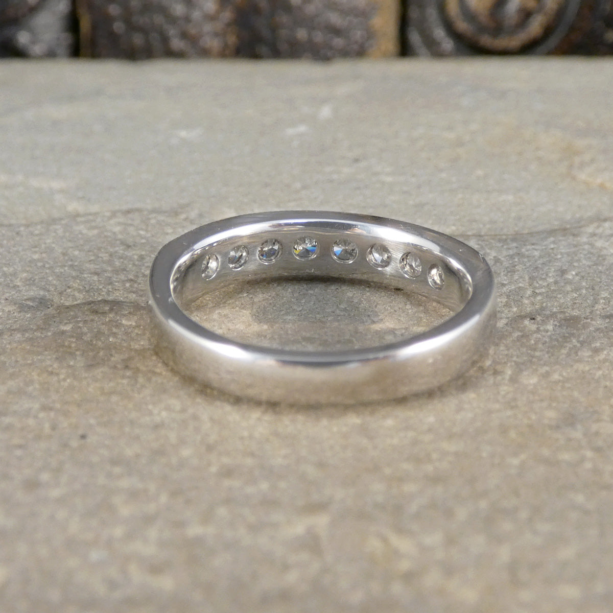 Back view of ring with diamonds on a textured surface