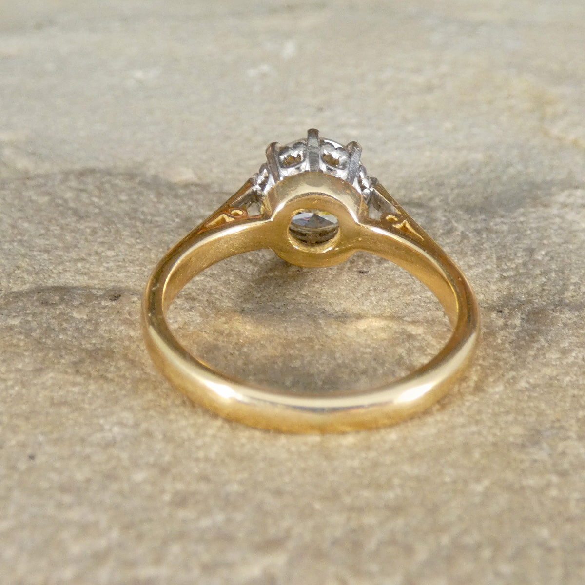 Gold ring with a diamond on a textured surface