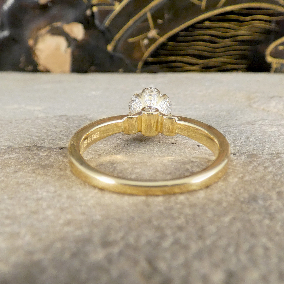 Gold ring with a diamond on a textured surface