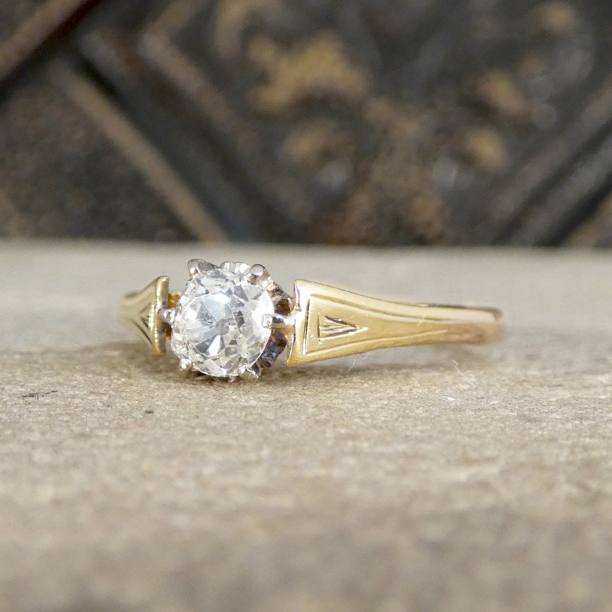 Gold ring with a diamond on a textured surface