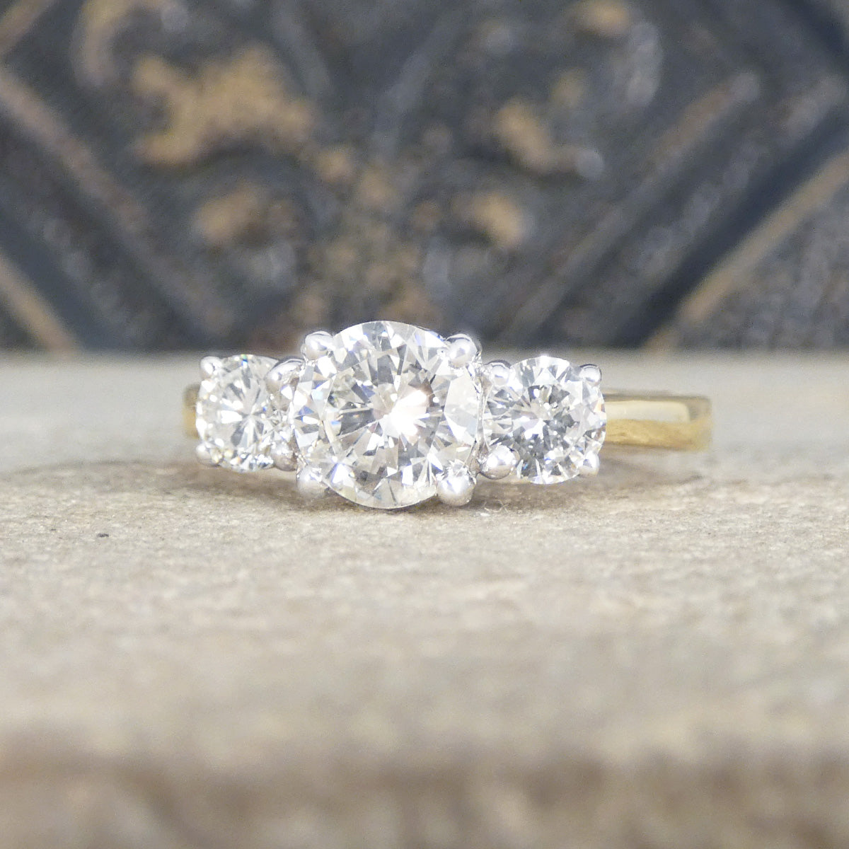 Diamond engagement ring with a textured surface in the background