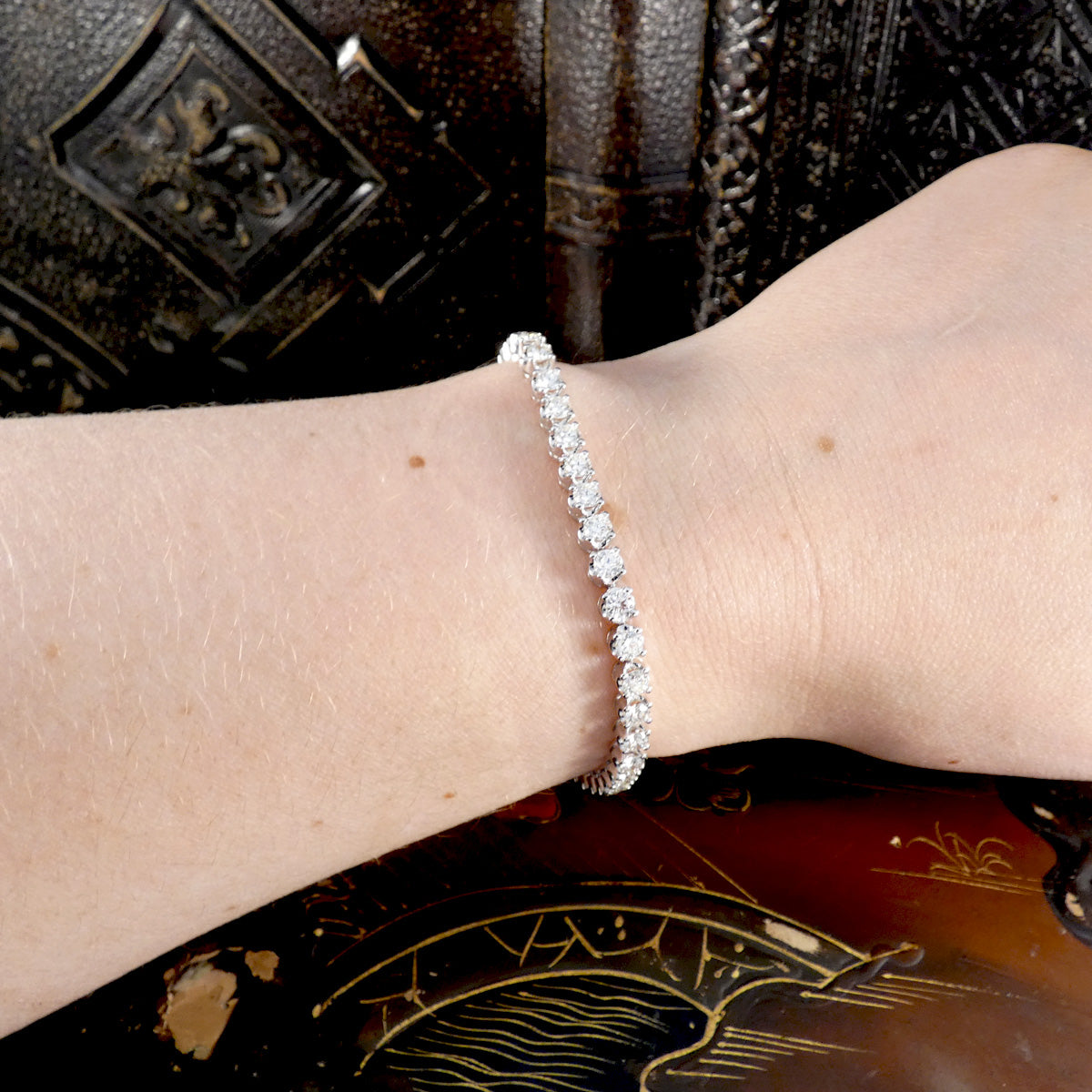 Elegant platinum diamond tennis bracelet worn on wrist, featuring a continuous row of sparkling round-cut diamonds in a four-claw setting, perfect for luxury fine jewelry enthusiasts.