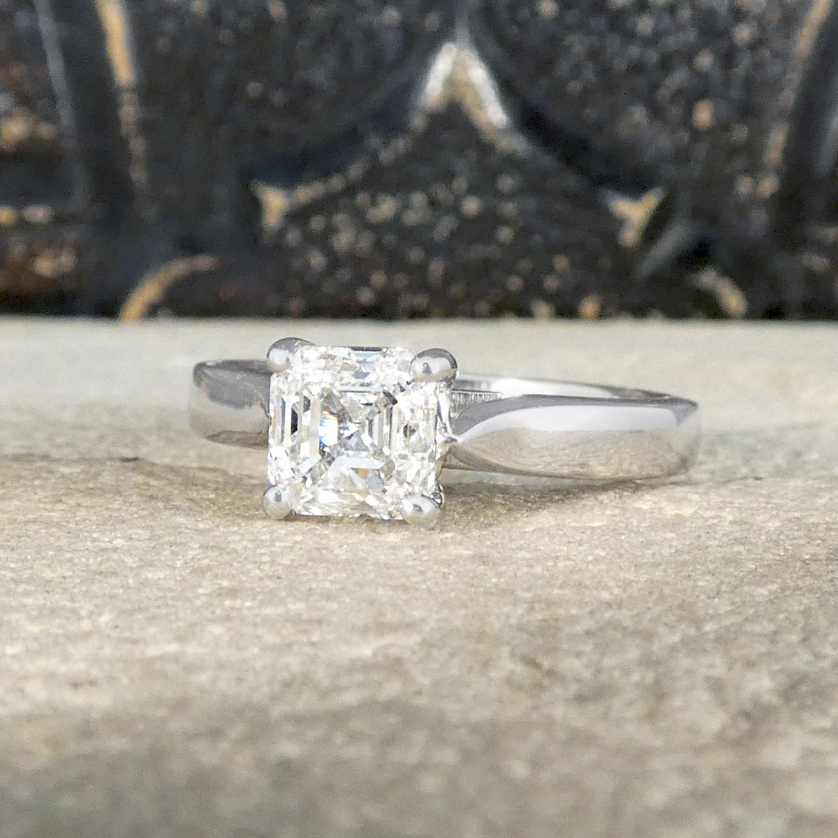 A Squared Emerald Cut Diamond Solitaire Engagement Ring in a four claw setting with a chunky Platinum band and modern feel. GIA certified Diamond.