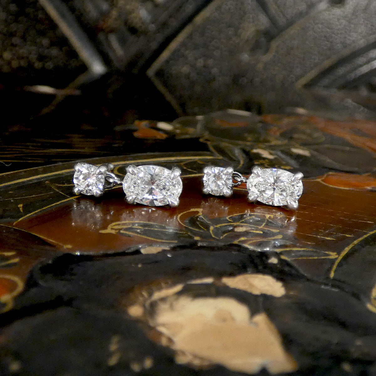 Pair of diamond earrings on a decorative surface