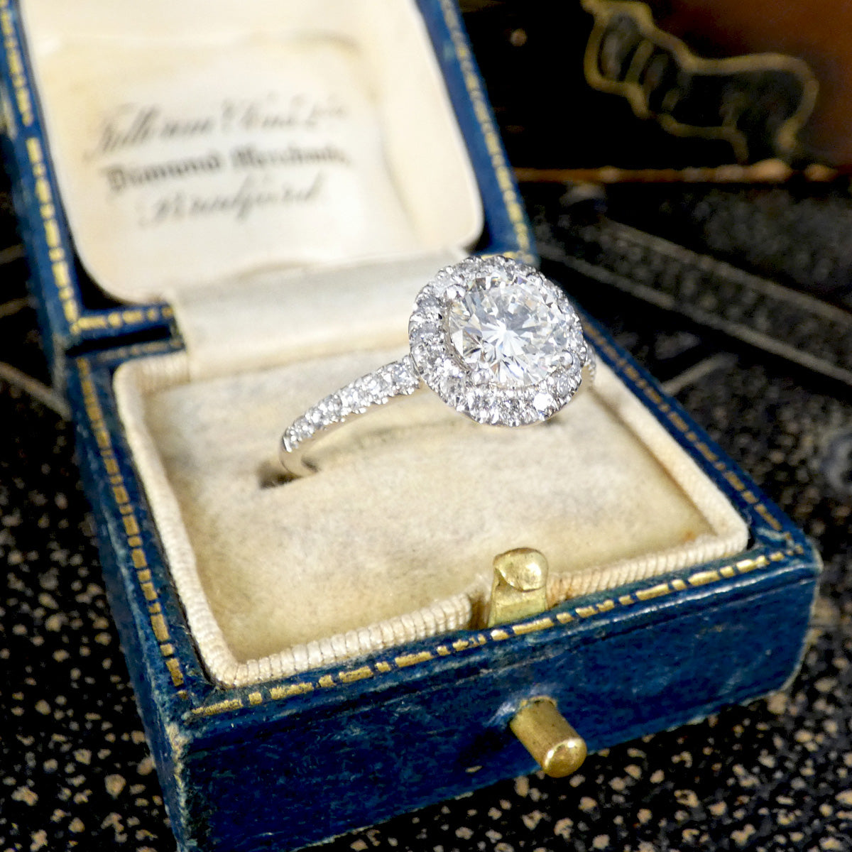 Diamond ring in a blue velvet box on a textured surface