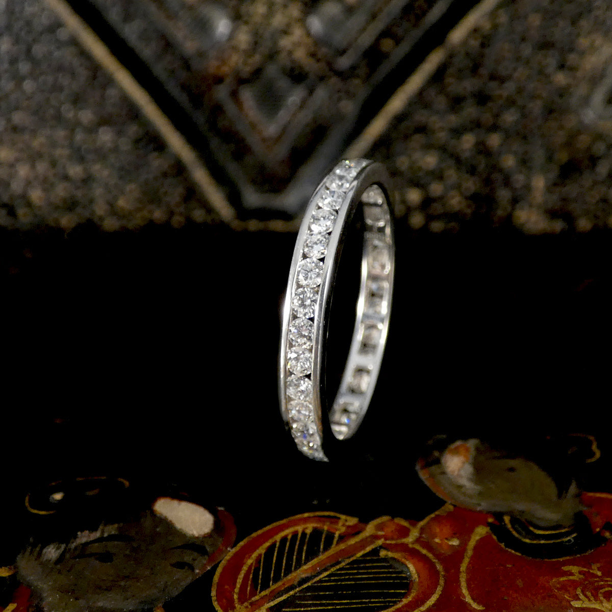 Platinum full eternity ring with diamonds on a textured surface