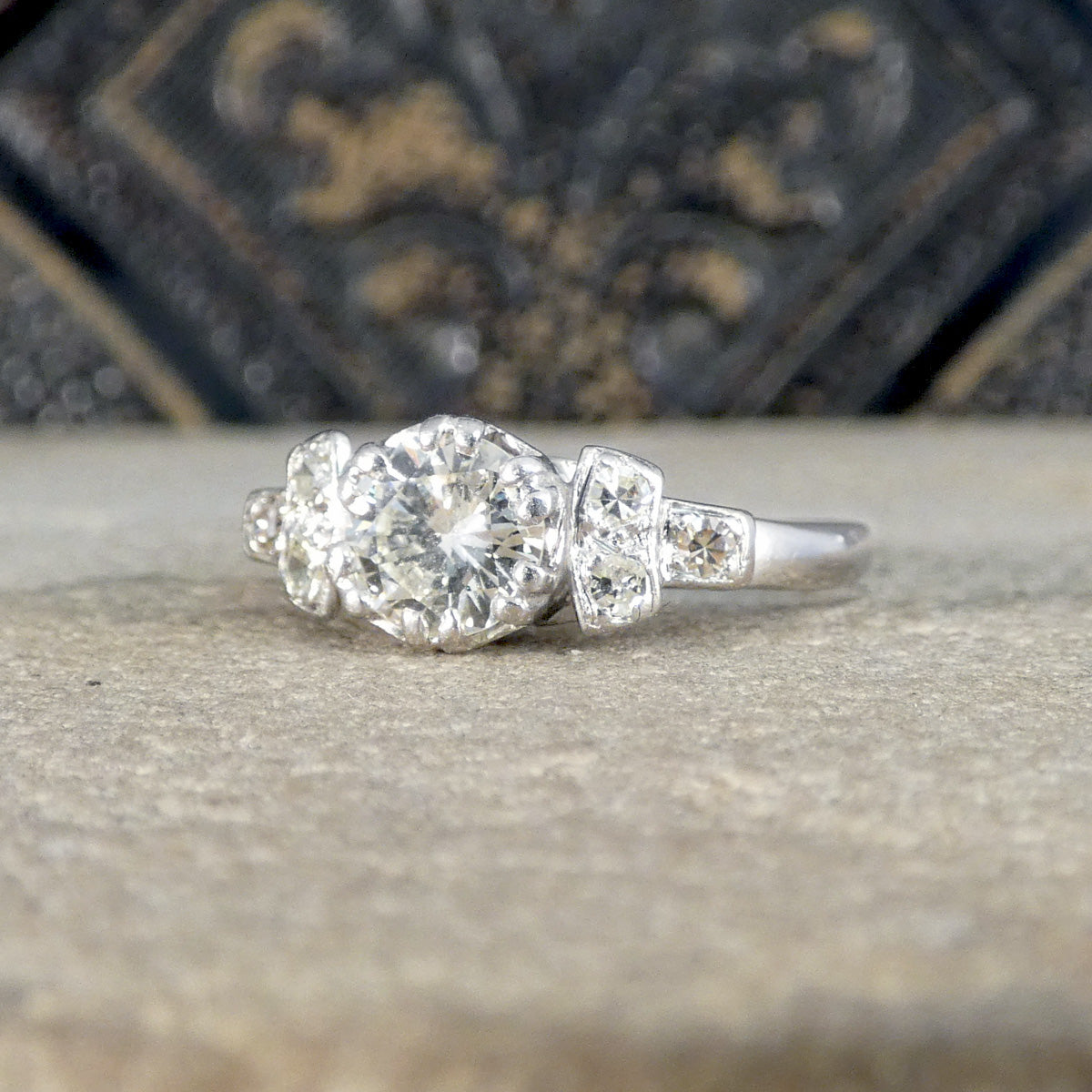 Diamond vintage ring on a textured surface with a decorative background