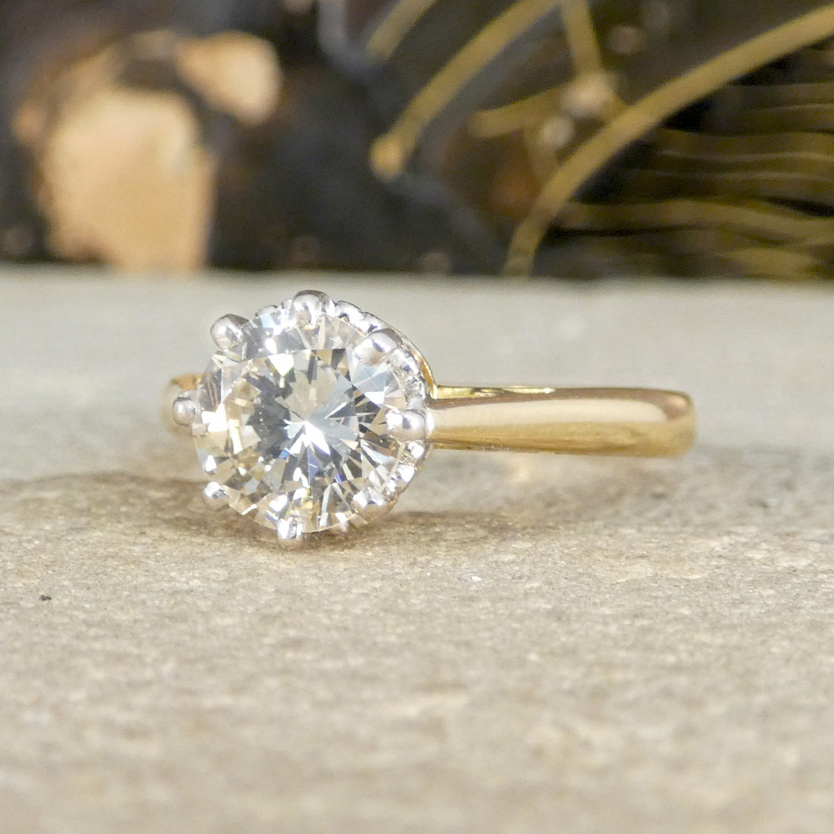 Gold ring with a large diamond on a textured surface
